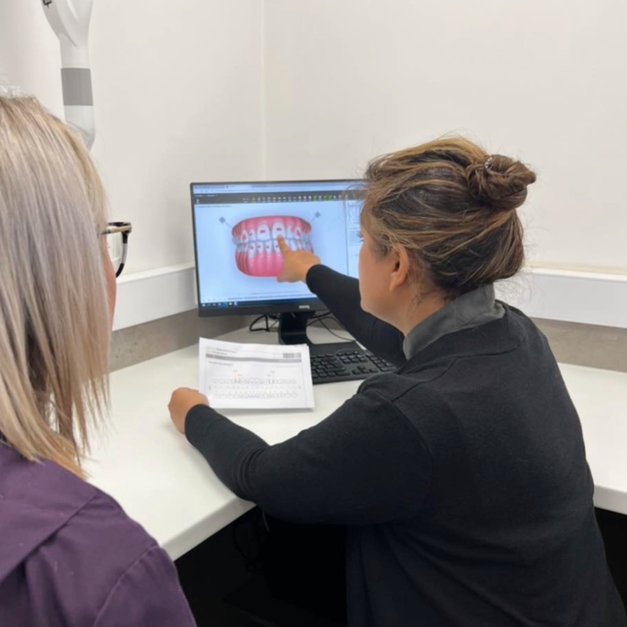A patient and clinician reviewing an Invisalign treatment plan on screen