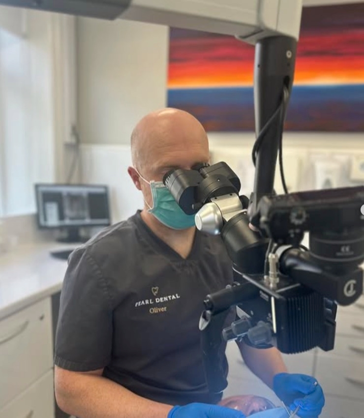 Dr Oliver Kenyon working through a surgical microscope