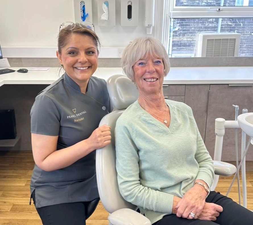 Dr Narinder Khroud beside a patient in the treatment chair, both smiling