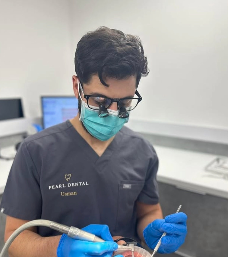 Dr Usman Asghar treating a patient wearing loupes