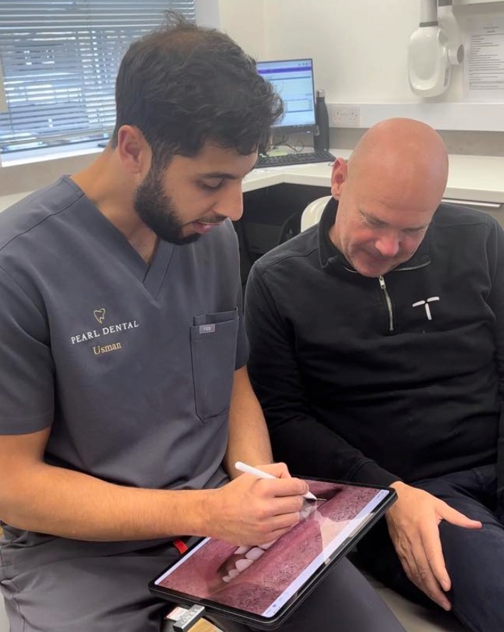 Dr Usman Asghar going through a digital scan with a patient on an iPad